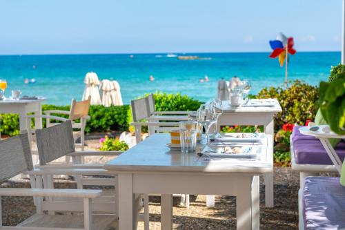 a table on the beach with the ocean in the background at Talgo Suites in Stalida