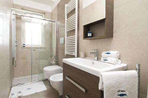 a bathroom with a sink and a toilet and a shower at Vilu Suite Mare in Polignano a Mare