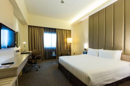 a hotel room with a bed and a desk and a television at Sunway Hotel Seberang Jaya in Perai