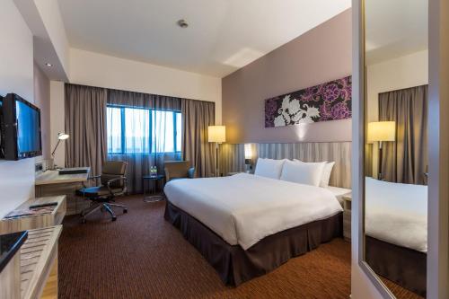 a hotel room with a large bed and a tv at Sunway Hotel Seberang Jaya in Perai