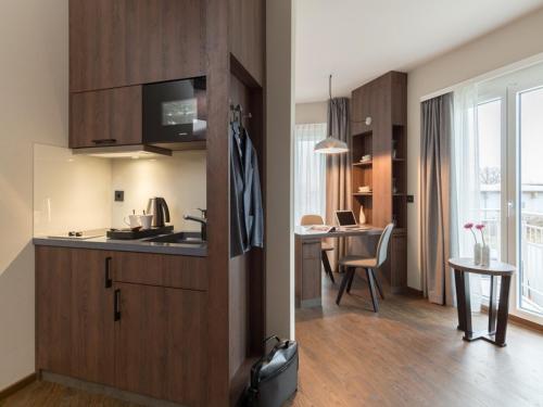 a kitchen with wooden cabinets and a dining room at Hotel Smartino in Schwäbisch Hall