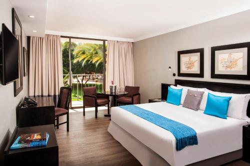 a hotel room with a large bed and a table at Avani Maseru Hotel in Maseru