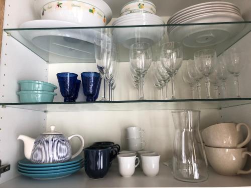 une étagère remplie de verres, d'assiettes et de vaisselle dans l'établissement L'authentique, à Honfleur