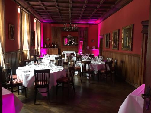 Residenz Kommende في بون: غرفة طعام بها طاولات وكراسي وإضاءة وردية