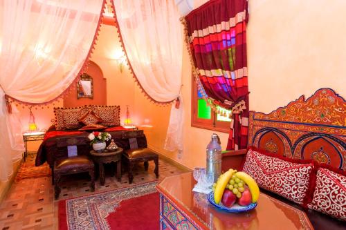Un dormitorio con una cama y una mesa con un bol de fruta en Riad bleu du Sud, en Marrakech