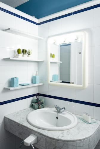 a white bathroom with a sink and a mirror at Apartamento Vista Farallón in Gáldar