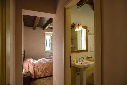 y baño con cama, lavabo y espejo. en Agriturismo Colle Tocci, en Subiaco