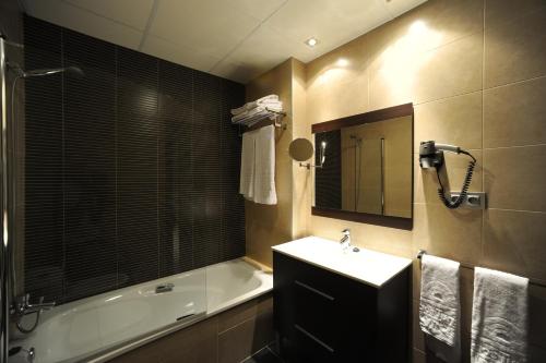 a bathroom with a tub and a sink and a bath tub at Leo Deluxe Punta Umbría in Punta Umbría