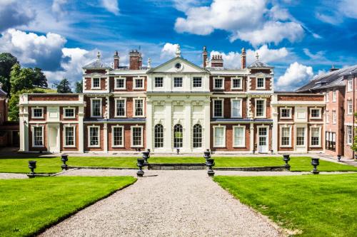 a large house with a grass yard in front of it at Hawkstone Hall Hotel & Gardens in Shrewsbury