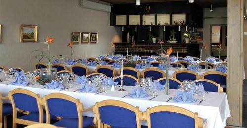 a room with a table and chairs with blue napkins at Hotel Rødding in Rødding
