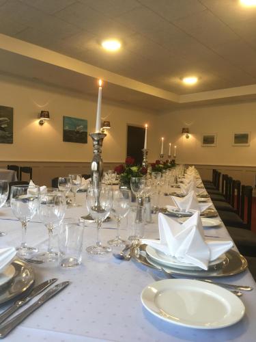 a long table with glasses and napkins on it at Hotel Rødding in Rødding