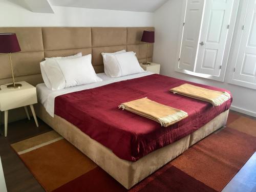 a bedroom with a large bed with two towels on it at Casas Rosa Sousa in Felgueiras