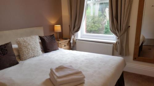 a bedroom with a bed with two folded towels on it at Rylstone Mere in Whitby