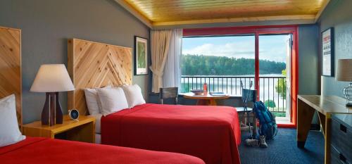 a hotel room with two beds and a large window at Lake House at High Peaks Resort in Lake Placid