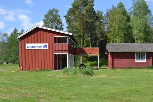 a red barn with a sign on the side of it at First Camp Enåbadet - Rättvik in Rättvik