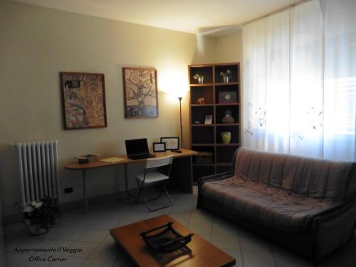 a living room with a couch and a desk at Appartamento il Veggio in Poggio a Caiano