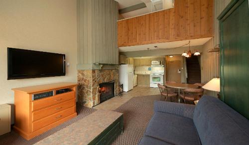 a living room with a couch and a fireplace at Douglas Fir Resort & Chalets in Banff