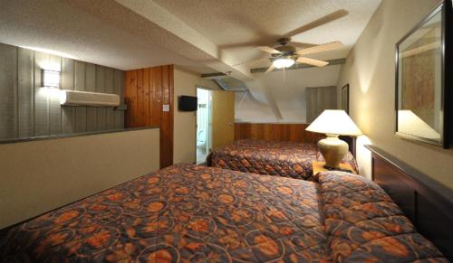 a hotel room with two beds and a lamp at Douglas Fir Resort & Chalets in Banff