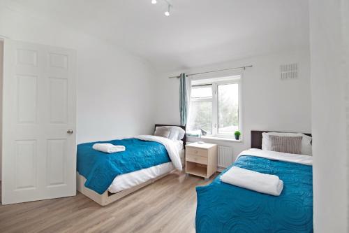 a bedroom with two beds and a window at Dagenham Self catering House for Larger Groups with Free Parking in Dagenham
