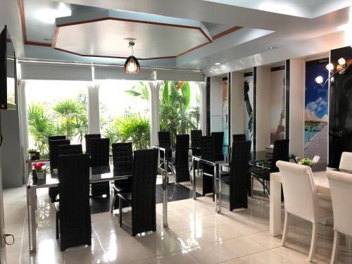 comedor con sillas negras y mesa en Atikarn Princess Hotel & Resort, en Udon Thani