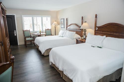 a hotel room with two beds and a table at Casa Ojai Inn in Ojai