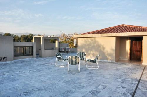 a patio with chairs and a table and a house at Reina Boutique Hotel - G9 in Islamabad