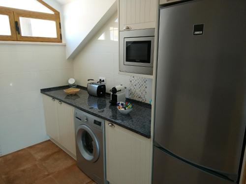 a kitchen with a refrigerator and a washing machine at Ribalta Beach Houses in Ericeira