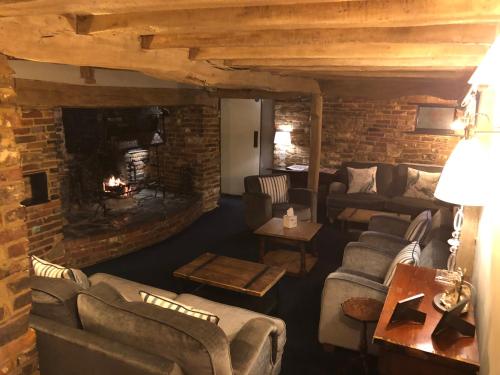 a living room with couches and a fireplace at Random Hall in Slinfold