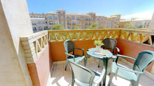 a patio with chairs and a table on a balcony at Leo Punta Umbría in Punta Umbría