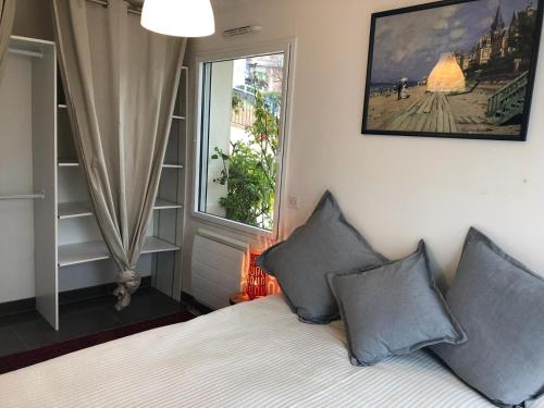 - une chambre avec un lit avec deux oreillers et une fenêtre dans l'établissement Superbe Deux pièces Vue Mer avec jardin, à Trouville-sur-Mer