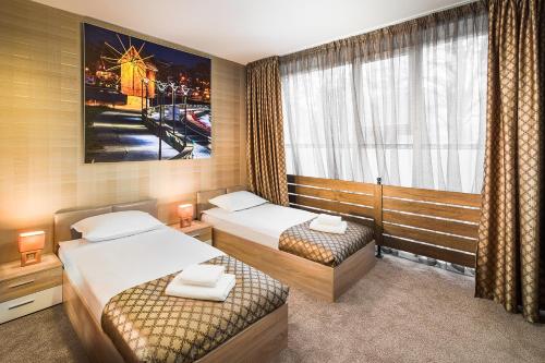 a hotel room with two beds and a window at Central Point Boutique Hotel in Sofia