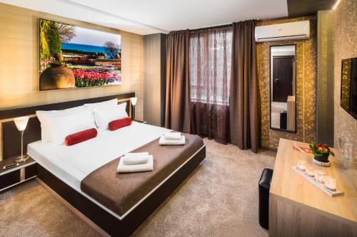 a hotel room with a large bed and a desk at Central Point Boutique Hotel in Sofia