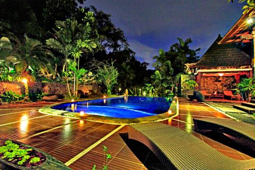 a swimming pool in the middle of a yard at night at Dewangga Ubud in Ubud
