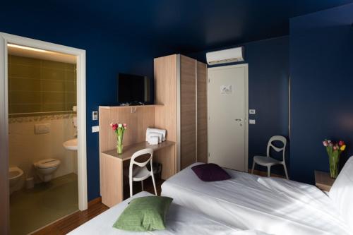 a blue bedroom with a bed and a bathroom at Albergo Residenza Al Teatro in Udine