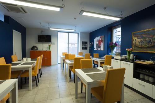 a dining room with tables and chairs and a kitchen at Albergo Residenza Al Teatro in Udine