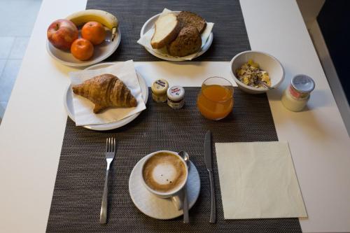 a table with plates of breakfast foods and a cup of coffee at Albergo Residenza Al Teatro in Udine