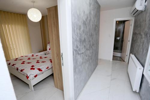 a bedroom with a bed with red flowers on it at Apartmani Mila in Laktaši