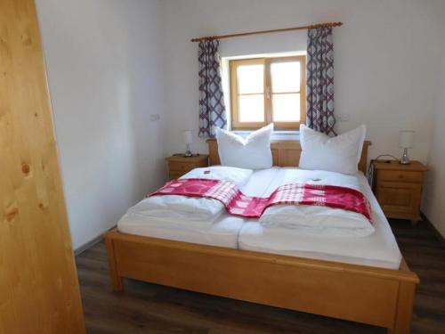 a bedroom with a large bed with a window at Ferienwohnung Linder in Hopferau