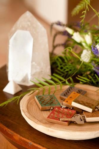 a wooden table with a plate with keys and flowers at Arkhé Hotel Boutique Pals in Pals