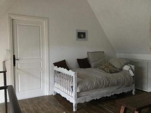 a bed in a room with a crib in a room at Maison de Sandrine in Jumeauville