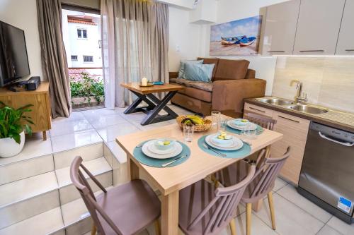 a kitchen and living room with a table and chairs at Lemar Luxury Apartments in Hersonissos