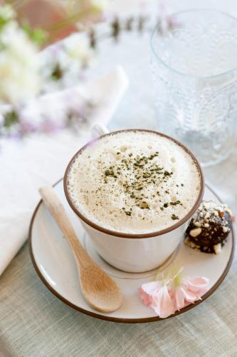 a cup of coffee on a plate with a spoon at Arkhé Hotel Boutique Pals in Pals