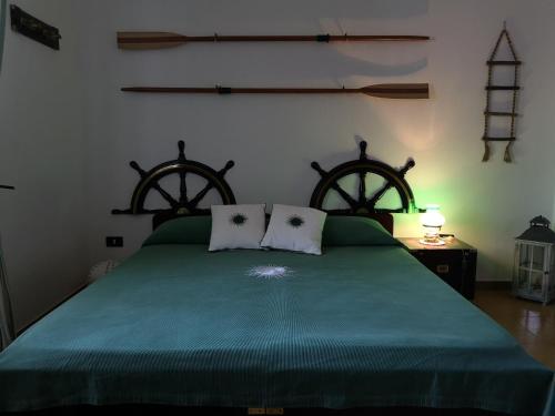 a bedroom with a green bed with two pillows at B&B Villa Ines in Leuca