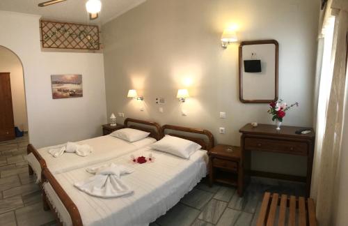 a bedroom with two beds and a mirror at Narkissos Studios in Aliki