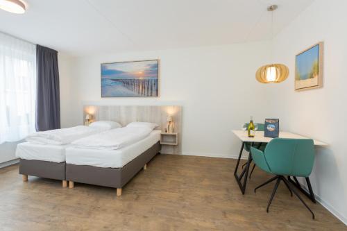 ein Hotelzimmer mit 2 Betten und einem Schreibtisch in der Unterkunft Aparthotel Zoutelande Luxe Studio 2 personen (huisdieren toegestaan) in Zoutelande