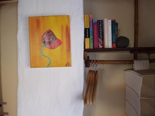 a painting of a flower on a wall next to a shelf at Madeira-Meerblick-Haus in Estreito da Calheta