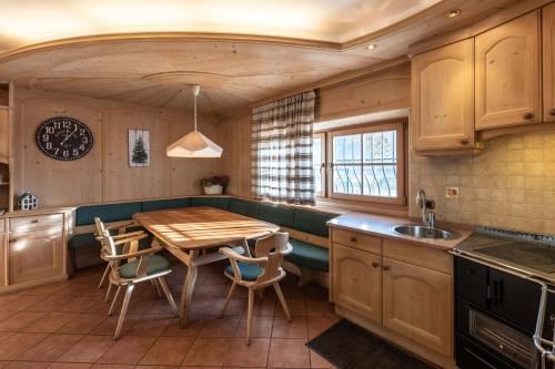 una cocina con mesa de madera y sillas. en Il Gallo, en Pergine Valsugana