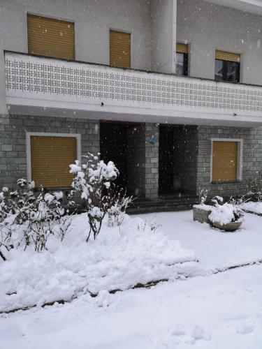 a building with snow on the ground in front of it at Casa Vacanze Santa Perpetua in Tirano