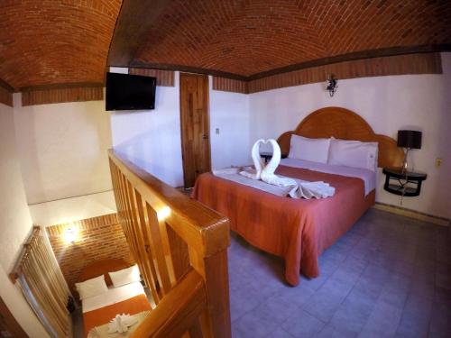 a bedroom with a bed with a swan on it at Suites Paraiso Tequis in Tequisquiapan