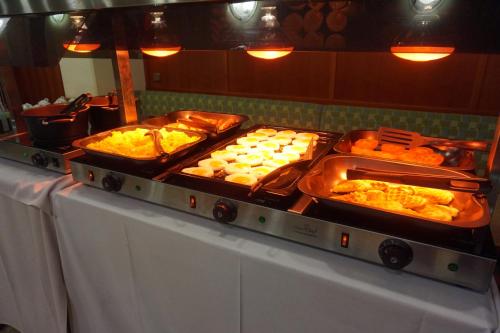 a buffet with several trays of food on a table at Hotel Untermetzger in Zell am Ziller